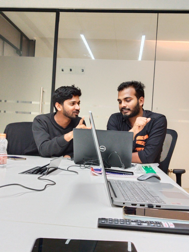 Team members reviewing work on a laptop